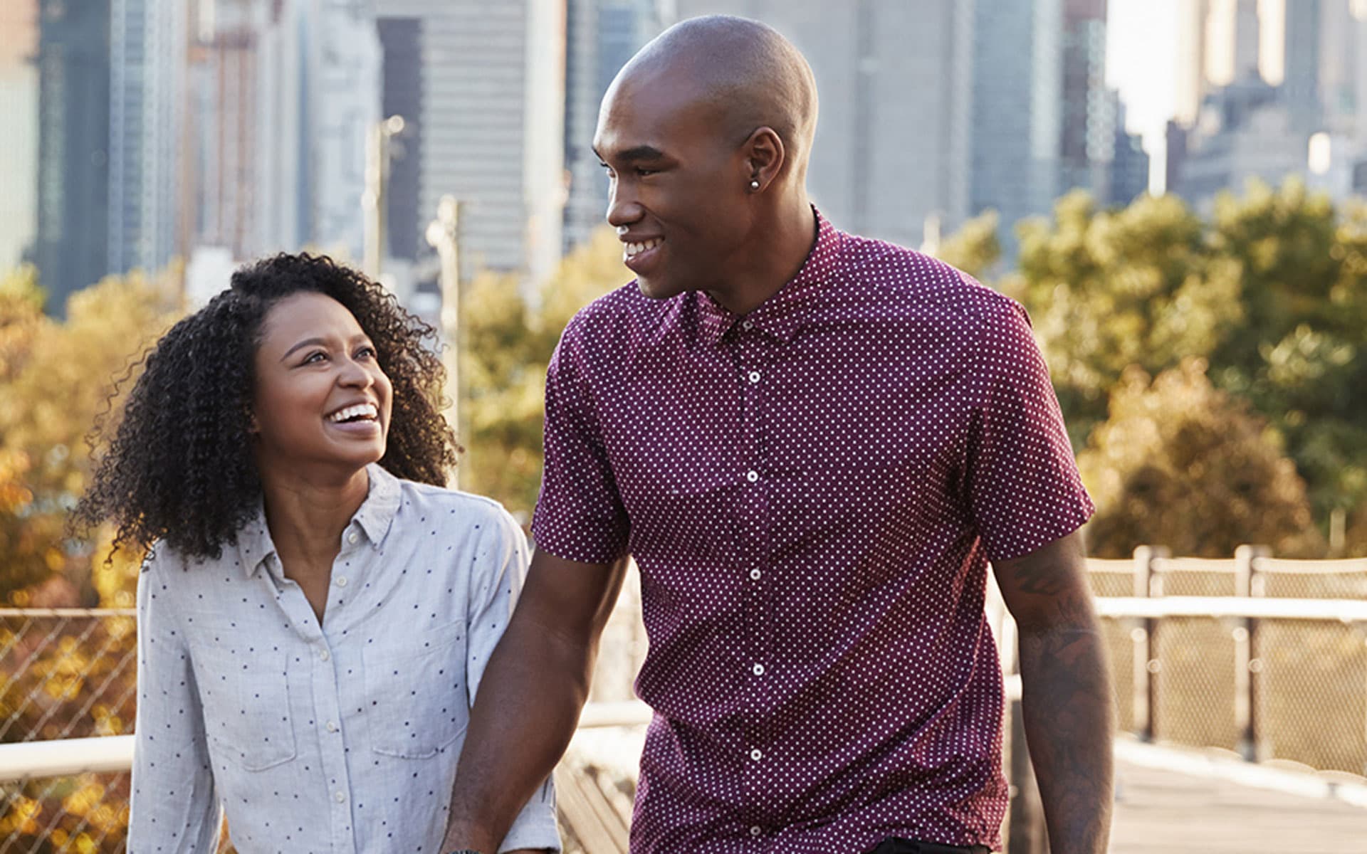 Man and woman walking in the city holding hands.